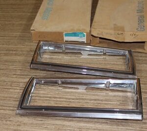 NOS GM 81-85 Impala Headlight Bezel Set 14015122 14015121