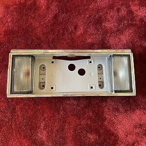 NOS 1989-1993 CADILLAC DEVILLE LICENSE PLATE TRIM PANEL WITH REAR BACK UP LIGHT
